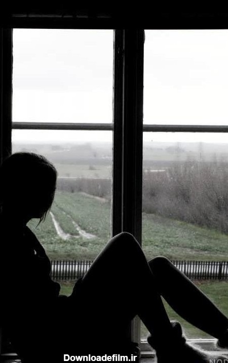 عکس دختری غمگین کنار پنجره