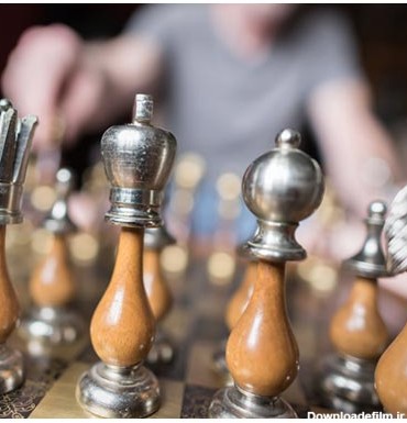 عکس مهره های زیبای شطرنج با پایه فلزی و پس زمینه بازیکن حریف