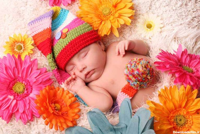 دانلود تصویر باکیفیت نوزاد خوابیده و گل های رنگی
