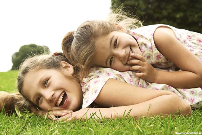 دانلود تصویر با کیفیت دختر دو بچه در حال خندیدن در فضای باز