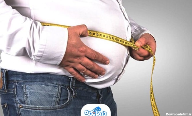 یک مرد چاق با متر دور شکم خود را اندازه می‌گیرد