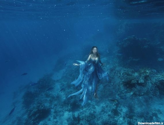 یک پری دریایی پری جادویی در لباس آبی پرواز در کف اقیانوس ملکه دریا ...