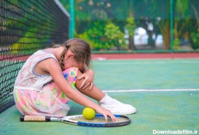 دانلود عکس دختر کوچک غمگین در زمین تنیس