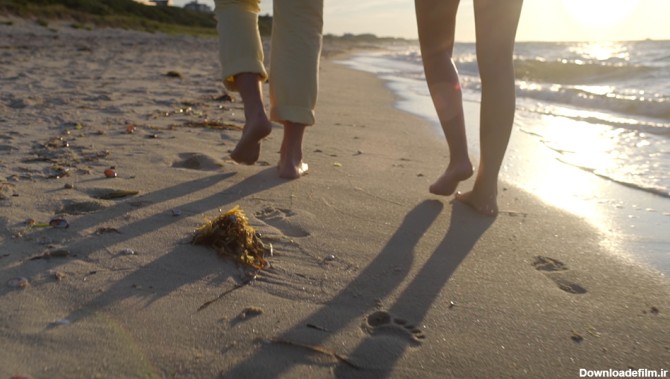 فوتیج کلوزاپ از قدم زدن یک زوج در کنار ساحل • مخزن ودره