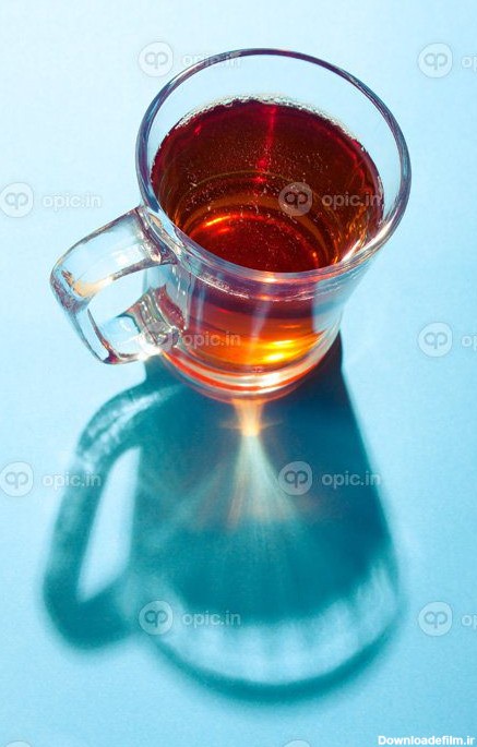 دانلود عکس لیوان چای در پس زمینه آبی زیر نور خورشید | اوپیک