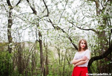 دانلود عکس پرتره دختر زیبا با لب های قرمز در شکوفه بهاری