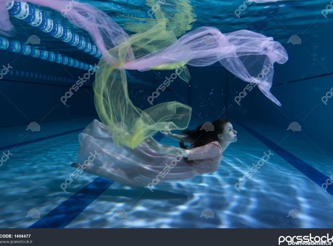 شناگر در زیر آب با یک پارچه بازی می کند او یک نمایش سرگرم کننده را ...