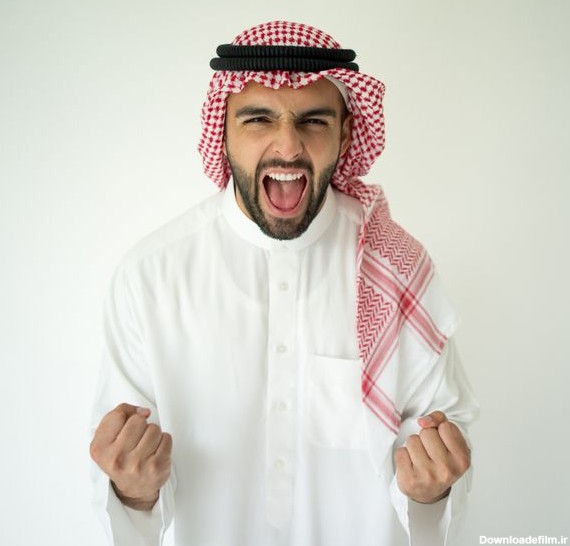 تاجر جوان عربی که روی دیوار قرمز ژست گرفته و در حال جشن ...