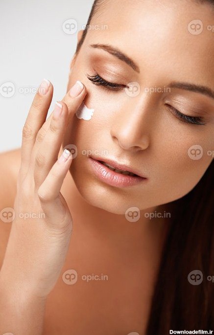 دانلود عکس پرتره مراقبت از پوست یک زن زیبا با کرم روی صورت | اوپیک