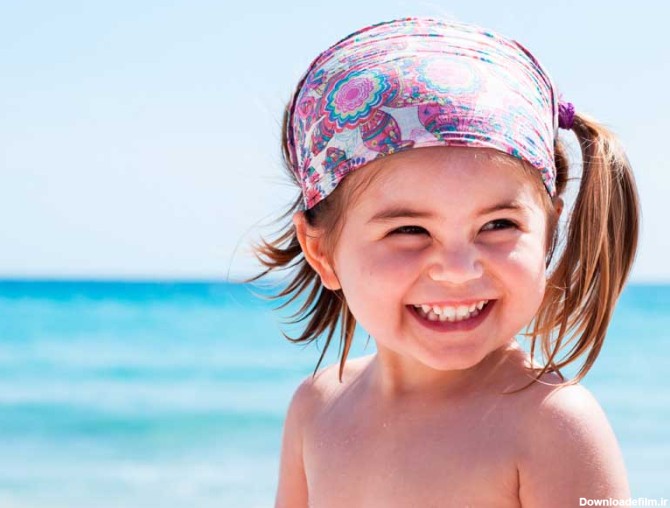 دانلود تصویر با کیفیت دختر بچه شاد و خندان در کنار آب