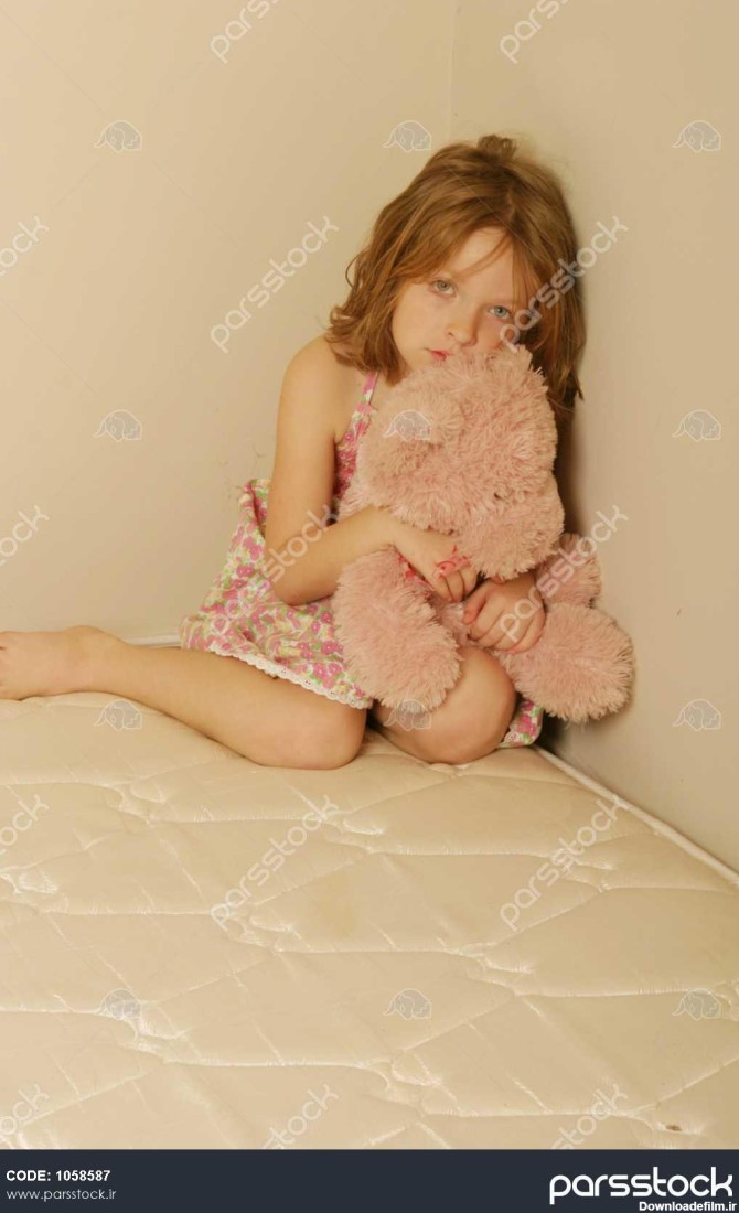 کودک غمگین نشسته به تنهایی در تشک قدیمی با یک خرس عروسکی 1058587