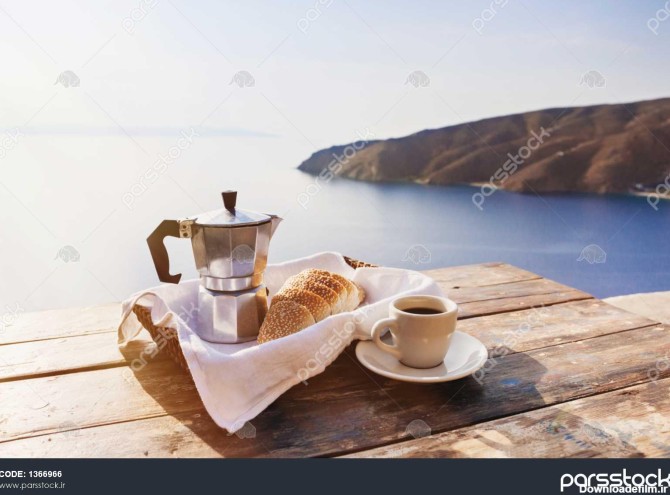 صبحانه مدیترانه ای فنجان قهوه و نان تازه بر روی یک میز با منظره ی ...