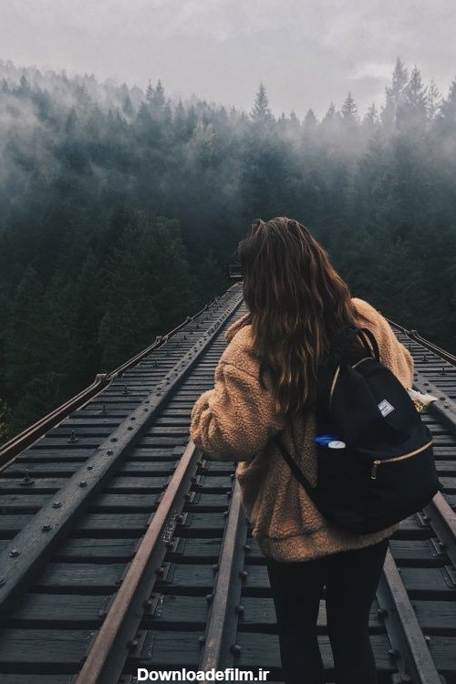 دانلود تصویر دختر در ریل قطار در وسط جنگل تاریک