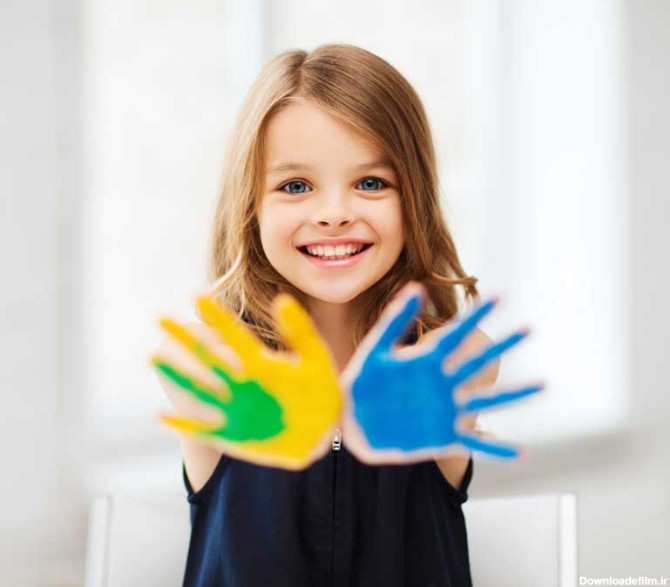 دانلود تصویر با کیفیت دختر بچه خندان با دستان رنگی
