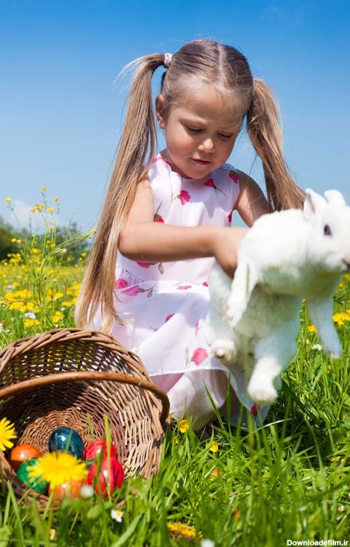 دانلود تصویر با کیفیت دختر بچه در حال بازی با خرگوش در طبیعت