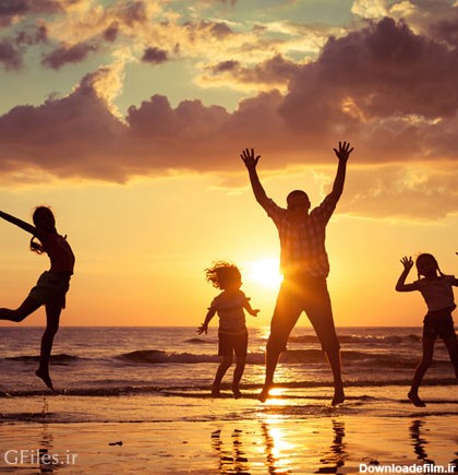 عکس طلوع خورشید در ساحل دریا و بازی خانواده چهار نفره