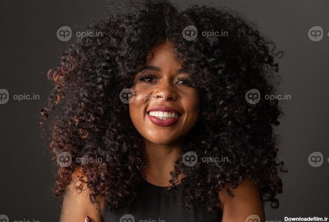 دانلود عکس زن جوان آفریقایی-آمریکایی با موهای مجعد که به دوربین ...