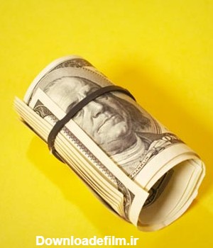 عکس اسکناس دلار لوله شده قرار گرفته بر روی زمینه زرد