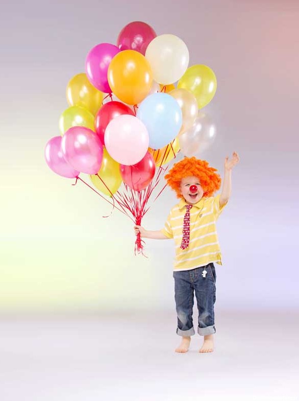 دانلود تصویر با کیفیت کودک شاد با کلاه دلقک و بادکنک های رنگی