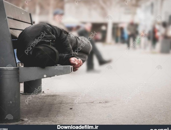 مرد فقیر بی خانمان و یا پناهنده در خواب بر روی نیمکت چوبی در ...