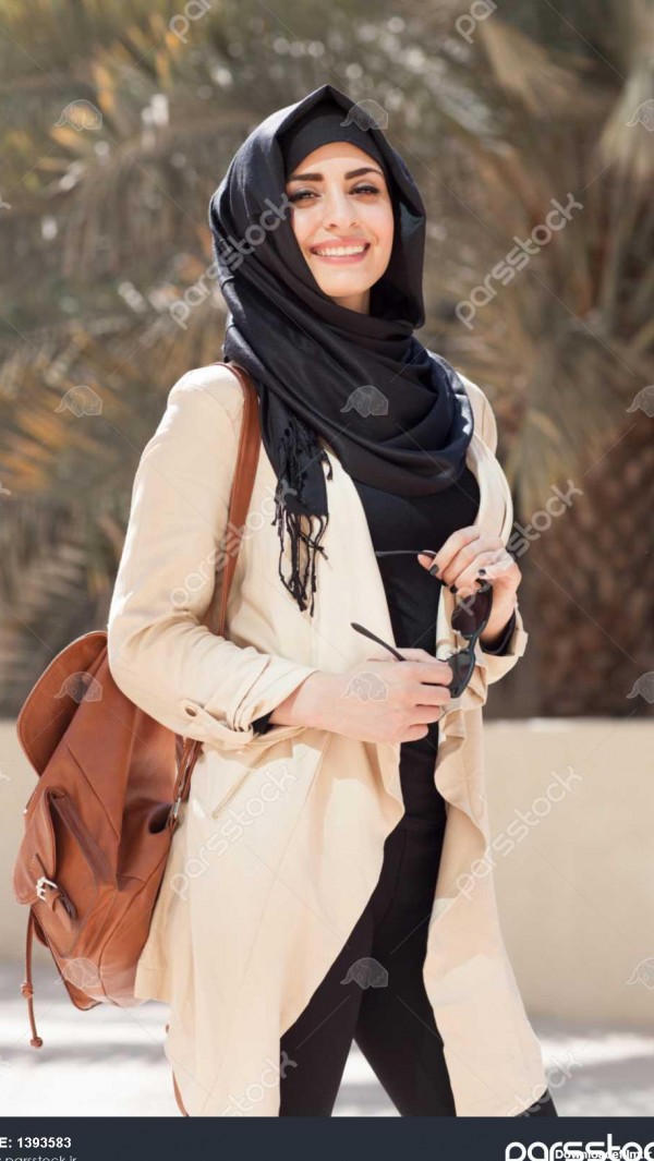 دختر لبخند زده در حجاب چشم هایش را با شادی در دبی مارینا پوشش می ...