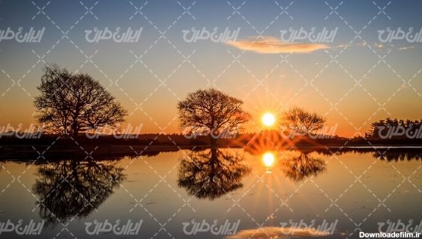 تصویر با کیفیت دریاچه زیبا همراه با منظره زیبای غروب آفتاب و درخت ...