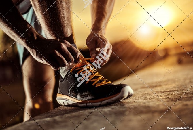 دانلود عکس مرد ورزشکار در حال پوشیدن کفش ورزشی