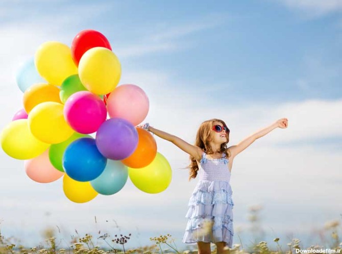 دانلود تصویر با کیفیت دختر بچه در حال شادی با بادکنک های رنگی