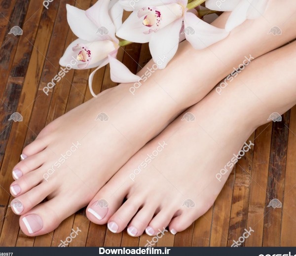 عکس نزدیک از پاهای زن با پدیکور فرانسوی سفید روی ناخن 1580977
