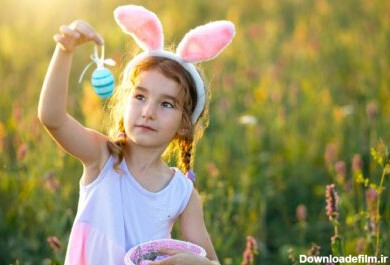 دانلود عکس دختر بامزه بامزه با تخم مرغ های رنگ شده عید پاک در بهار در طبیعت