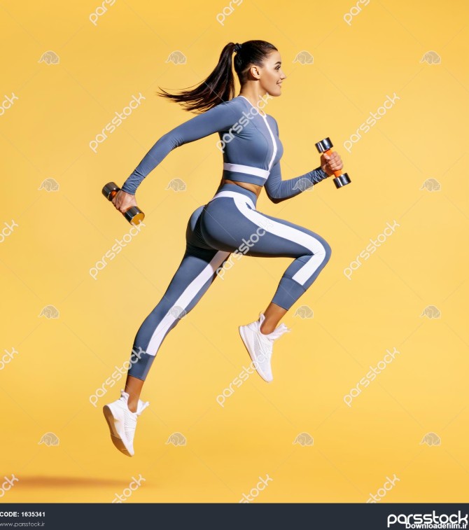 زن ورزشکار در حال پریدن با دمبل عکس زن فعال با لباس ورزشی در ...