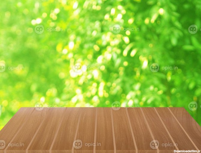 دانلود عکس میز چوبی قهوه ای روی پس زمینه طبیعت سبزه تار | اوپیک