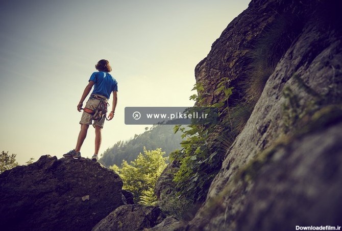 دانلود عکس شاتراستوک کوهنورد بر روی کوه سنگی