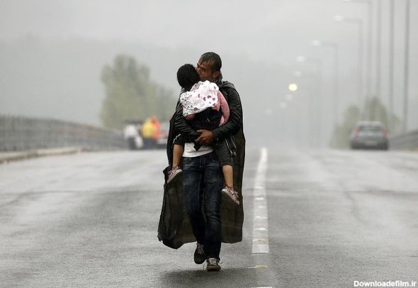 آخرین خبر | عکس/ کودک سوری در آغوش پدر زیر بارش باران