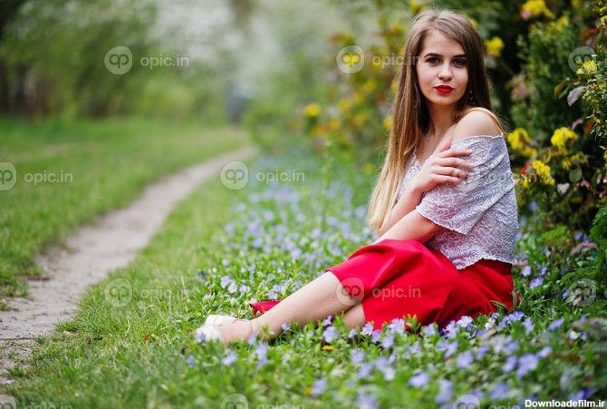 دانلود عکس پرتره نشستن دختر زیبا با لب های قرمز در بهار | اوپیک