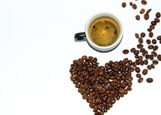 دانلود عکس یک فنجان اسپرسو با کف در کنار دانه های قهوه چیده شده