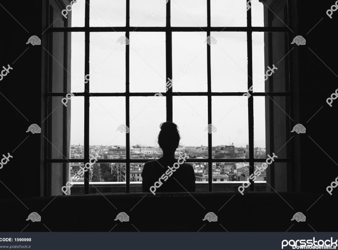 عکس سیاه و سفید از یک زن تنها که جلوی پنجره ها ایستاده و به ...