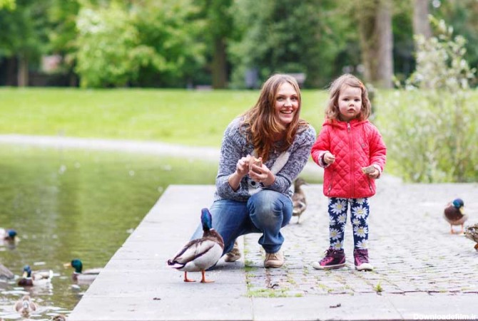 دانلود تصویر باکیفیت مادر و دختر بچه در حال غذا دادن به پرنده