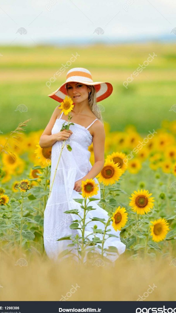 زن جوان در گل آفتابگردان زمینه در تابستان 1298386