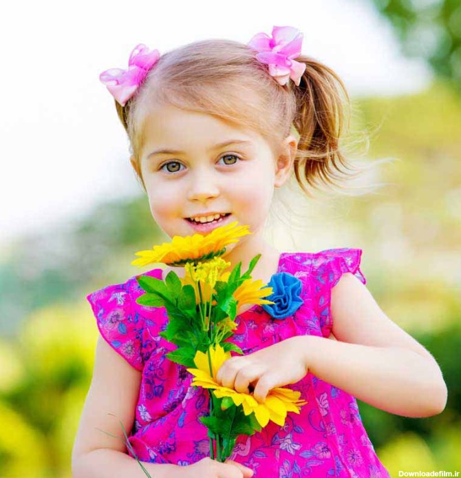 دانلود تصویر با کیفیت دختر بچه زیبا با چشمان بز و گل های زیبا