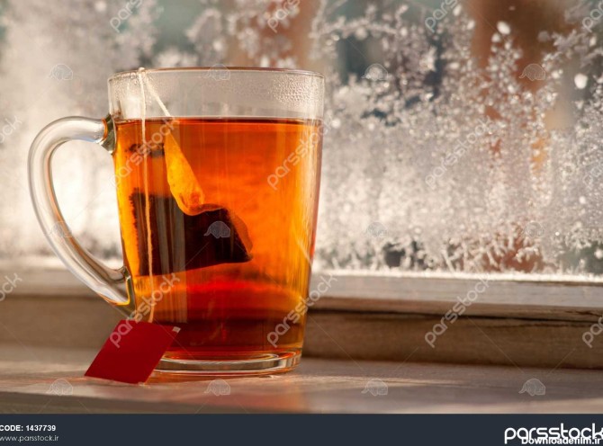 یک کیسه چای در یک لیوان یک لیوان چای بر روی پنجره بالکن در زمستان ...