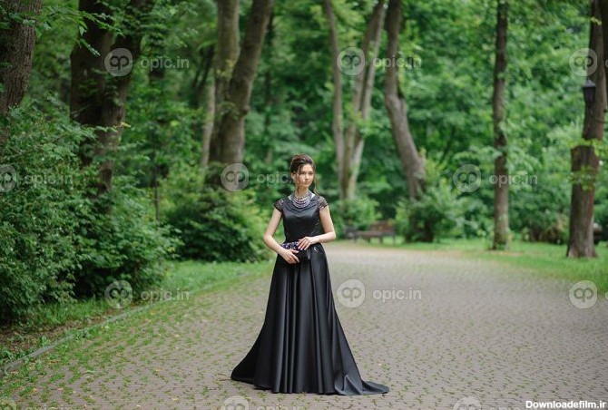دانلود عکس ژست زن جوان زیبا با لباس مشکی در پارک | اوپیک