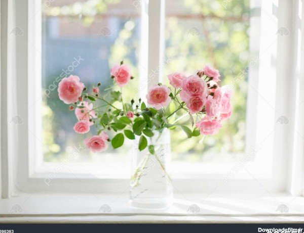 دسته گل رز تابستان در گلدان شیشه ای در نزدیکی پنجره 1390363
