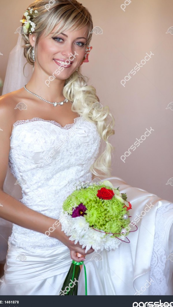 دختر عروس زیبا با لباس عروسی سفید با مدل مو و آرایش روشن در انتظار ...