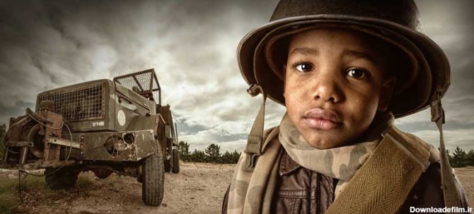 دانلود تصویر با کیفیت پسر سرباز در کنار ماشین جنگی