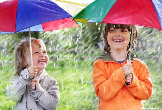 دانلود تصویر با کیفیت دو کودک زیر چتر و هوای بارانی