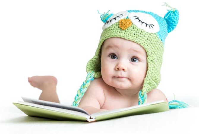دانلود تصویر با کیفیت نوزاد با کلاه زمستانی در حال کتاب خواندن