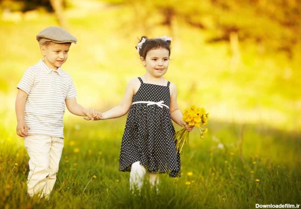 دانلود تصویر با کیفیت پسر و دختر در میان گلها در حال بازی