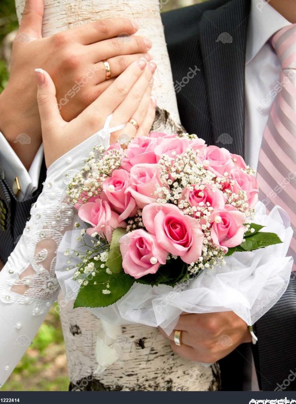 دست داماد و عروس در زمينه درختان توس با دسته گل گل 1222414