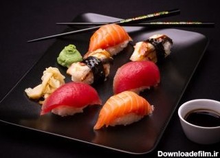 دانلود سوشی مارماهی ، ماهی قزل آلا و ماهی تن با chopsticks ، پس زمینه تیره